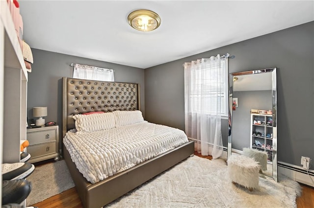 bedroom featuring baseboard heating and dark wood-type flooring