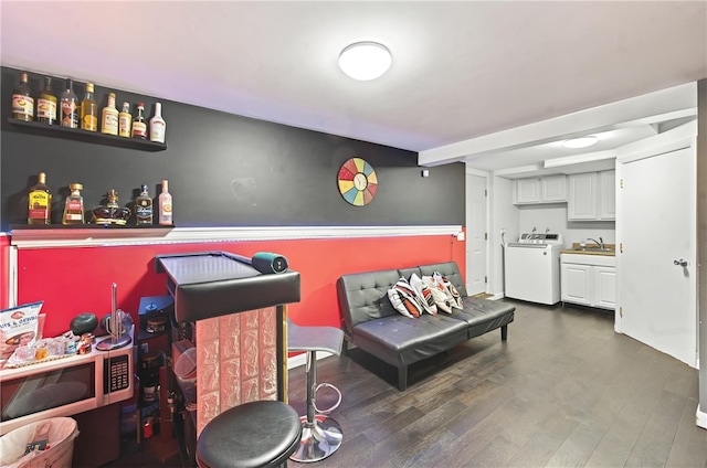 bar featuring washer / clothes dryer, white cabinetry, sink, and dark hardwood / wood-style flooring