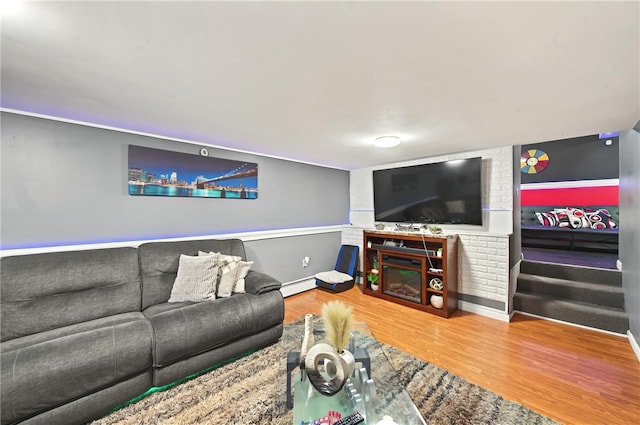 living room with a baseboard heating unit, hardwood / wood-style floors, and a fireplace