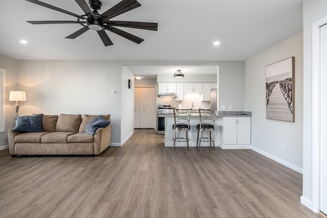 living room featuring ceiling fan and light hardwood / wood-style floors