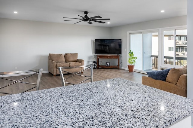 living room featuring wood-type flooring and ceiling fan