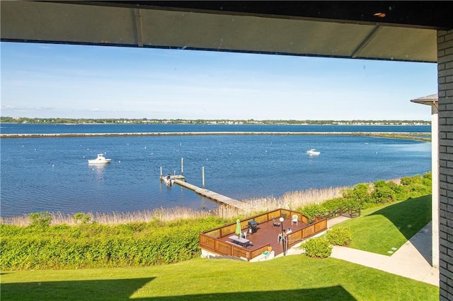 view of dock with a water view and a yard