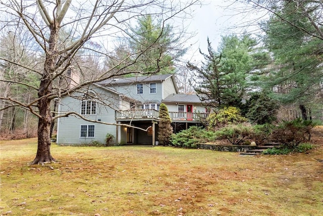 rear view of property featuring a wooden deck and a yard