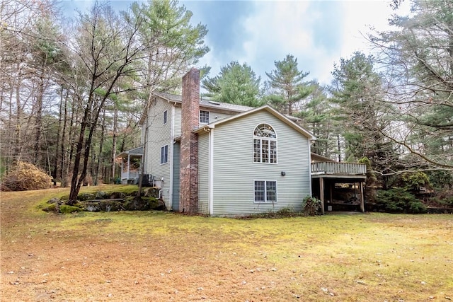 view of side of home featuring a wooden deck and a lawn