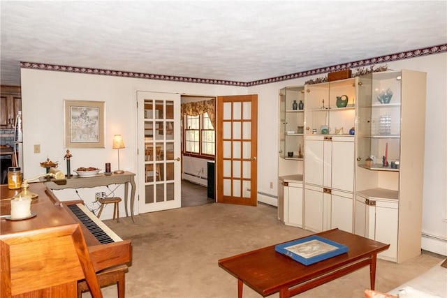 sitting room with light carpet, a baseboard heating unit, and french doors