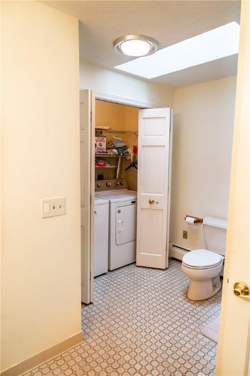 bathroom with washing machine and dryer and baseboard heating