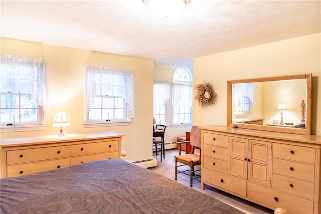 bedroom with multiple windows and a baseboard heating unit