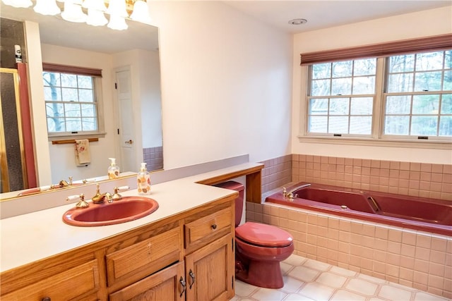 bathroom featuring tiled tub, vanity, and toilet