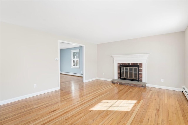 unfurnished living room with a fireplace, light hardwood / wood-style floors, and a baseboard heating unit