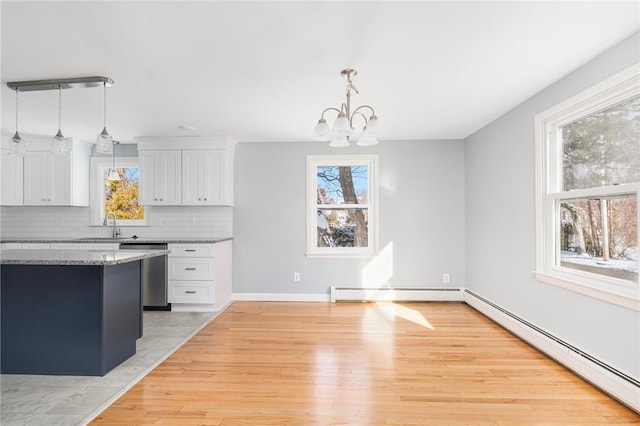 kitchen featuring white cabinetry, stainless steel dishwasher, pendant lighting, and baseboard heating