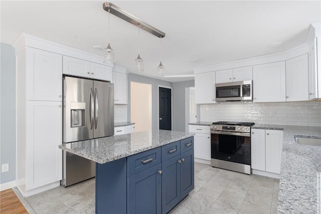 kitchen featuring blue cabinetry, light stone counters, hanging light fixtures, stainless steel appliances, and white cabinets