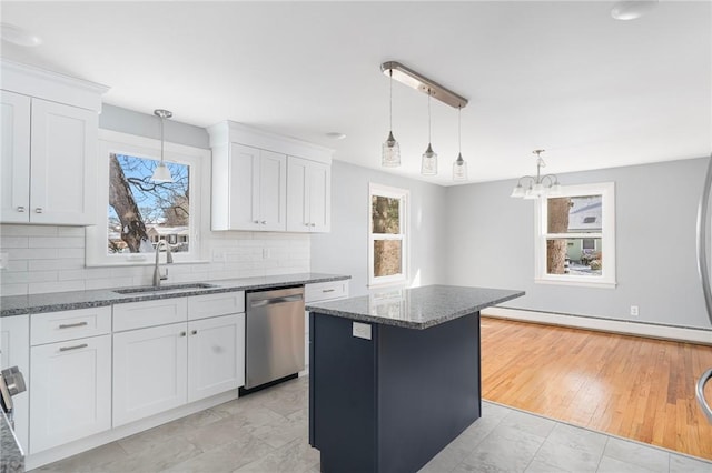 kitchen featuring pendant lighting, sink, dishwasher, white cabinetry, and a kitchen island