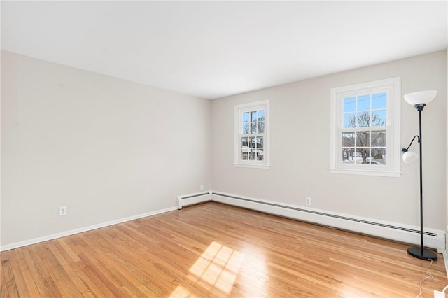 empty room featuring a baseboard radiator and light wood-type flooring