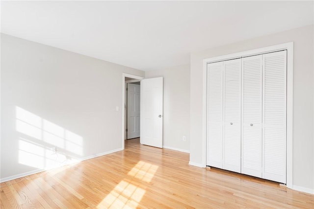 unfurnished bedroom featuring hardwood / wood-style floors and a closet