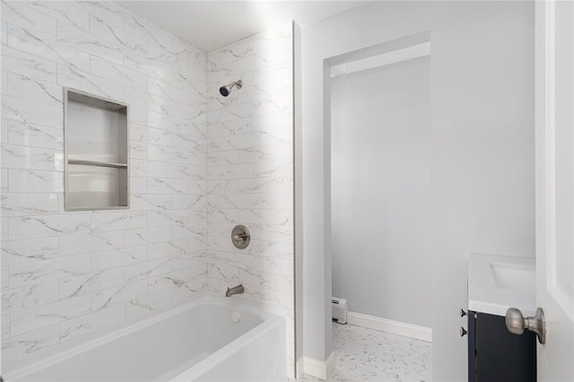 bathroom with tiled shower / bath combo, a baseboard radiator, and vanity