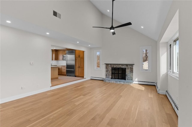 unfurnished living room featuring a stone fireplace, a baseboard radiator, and light hardwood / wood-style floors