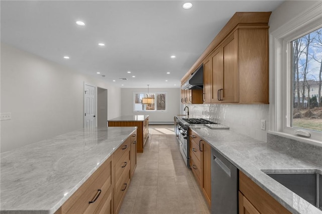 kitchen featuring decorative light fixtures, ventilation hood, a center island, stainless steel appliances, and light stone countertops