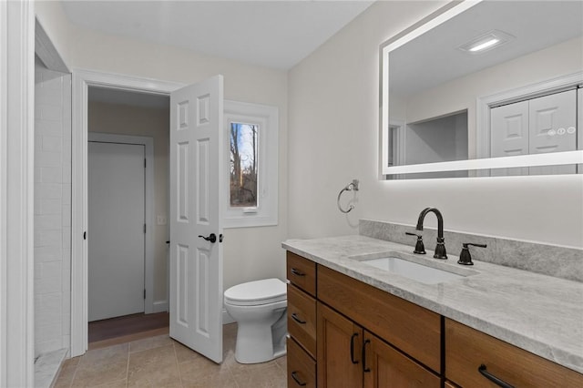 bathroom featuring vanity, tile patterned flooring, and toilet