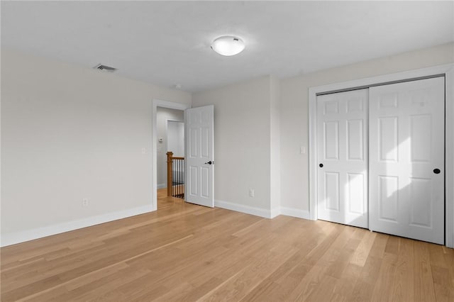 unfurnished bedroom with light hardwood / wood-style floors and a closet