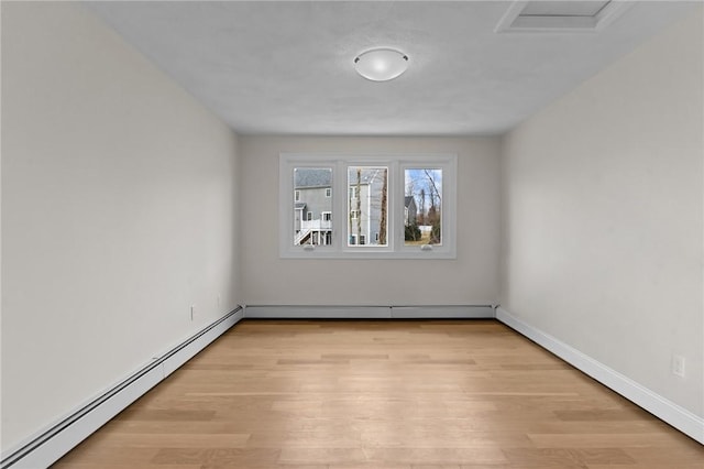 unfurnished room featuring light wood-type flooring and baseboard heating