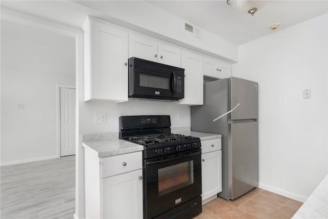 kitchen featuring white cabinetry, light stone counters, and black appliances