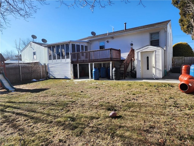 back of house with a wooden deck, a lawn, a sunroom, and a patio