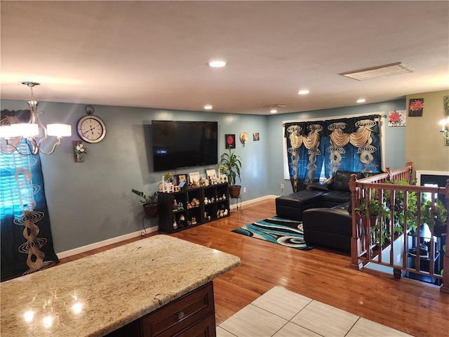 living room with a notable chandelier and light hardwood / wood-style floors