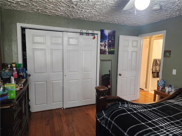 bedroom featuring ceiling fan, dark hardwood / wood-style floors, a textured ceiling, and a closet