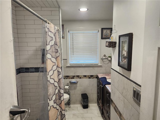 bathroom featuring vanity, tile walls, walk in shower, and toilet