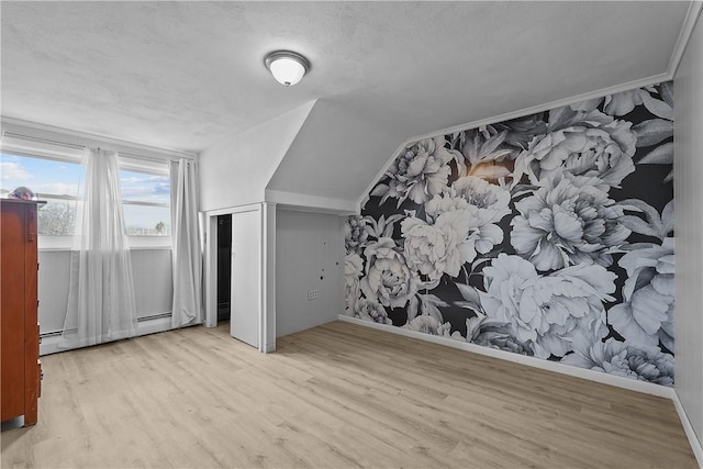 bonus room with lofted ceiling, a textured ceiling, light hardwood / wood-style floors, and baseboard heating