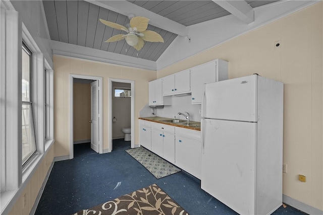 kitchen featuring sink, lofted ceiling with beams, white refrigerator, ceiling fan, and white cabinets