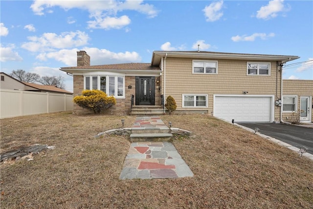 rear view of house with a garage and a lawn