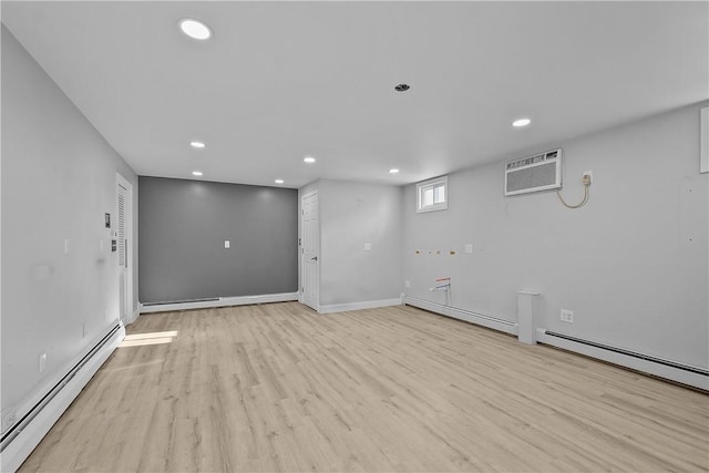 interior space with a baseboard heating unit, a wall mounted AC, and light wood-type flooring