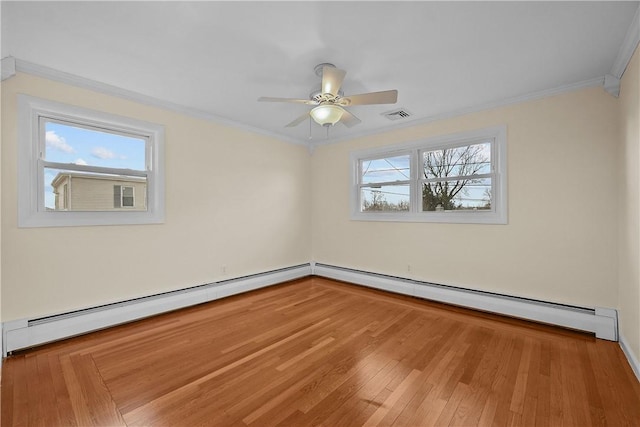 spare room featuring hardwood / wood-style flooring, crown molding, a baseboard heating unit, and ceiling fan