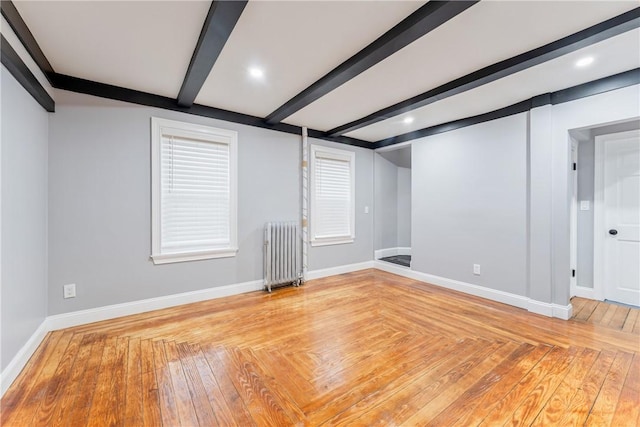 spare room with radiator heating unit and beamed ceiling