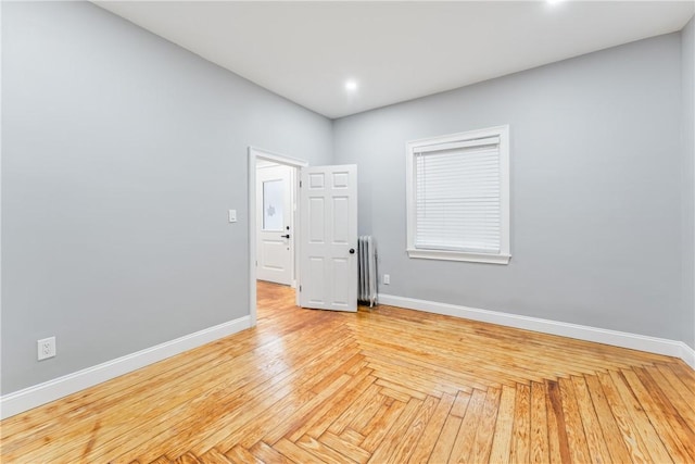 unfurnished room featuring radiator heating unit