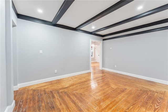 empty room featuring parquet floors and beamed ceiling