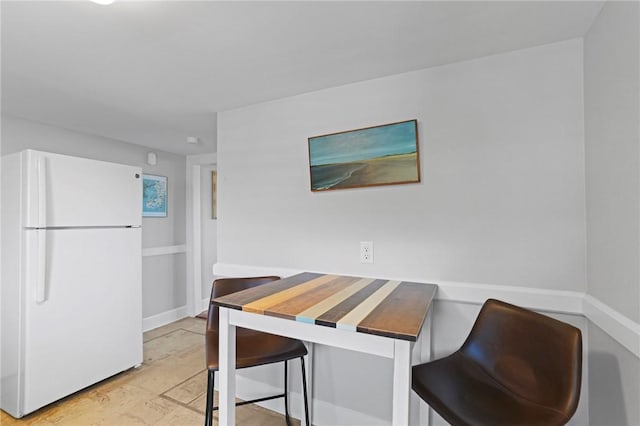 45 Ayrault St Unit 11, Newport, RI 02840 - kitchen featuring a breakfast bar area, white cabinets, and white refrigerator