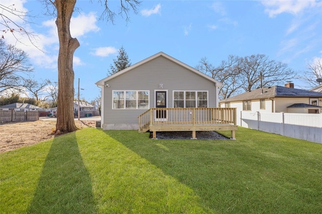 rear view of house featuring a wooden deck and a yard