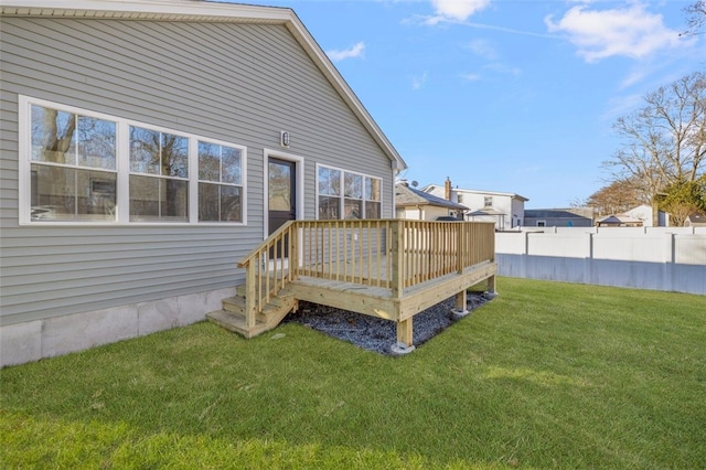 rear view of house featuring a wooden deck and a lawn