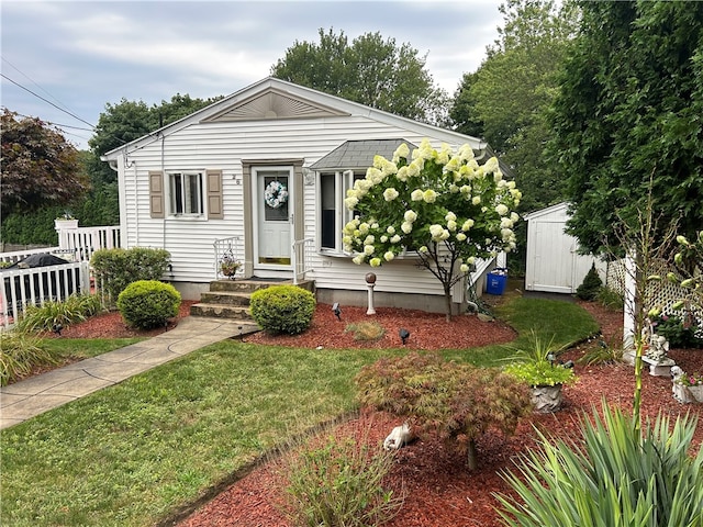 view of front of home with a storage unit and a front yard