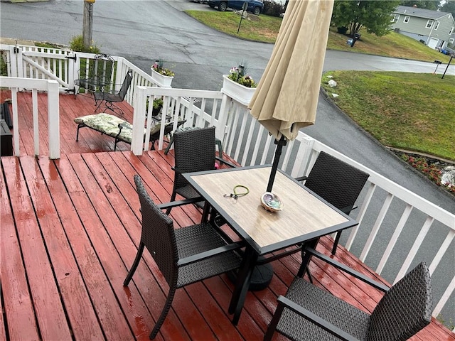 wooden terrace featuring a lawn