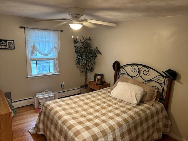 bedroom featuring ceiling fan, a baseboard radiator, and light wood-type flooring