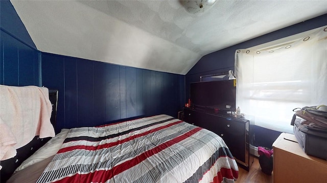 bedroom with lofted ceiling and a textured ceiling