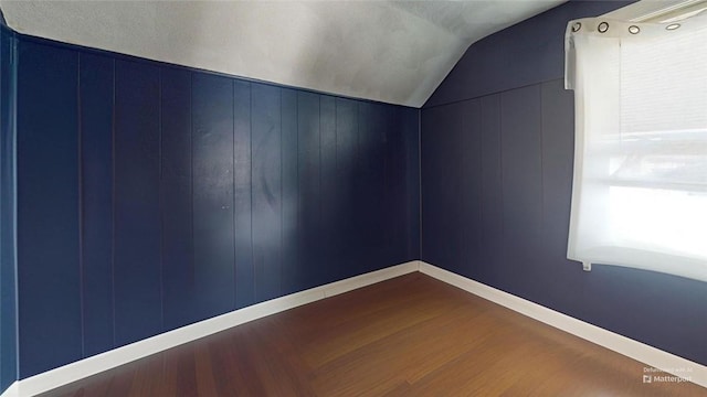 additional living space featuring lofted ceiling and hardwood / wood-style flooring