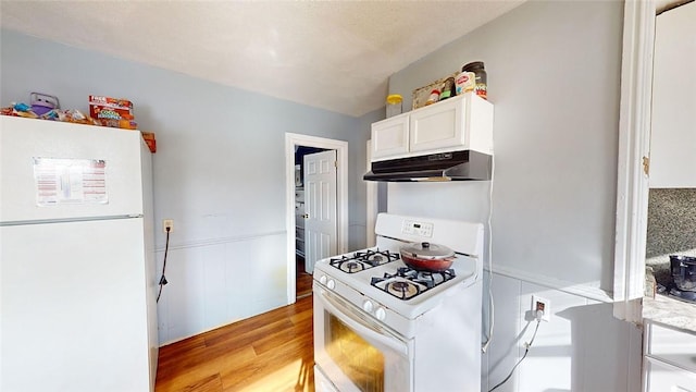 kitchen featuring white cabinets, white appliances, and light hardwood / wood-style flooring