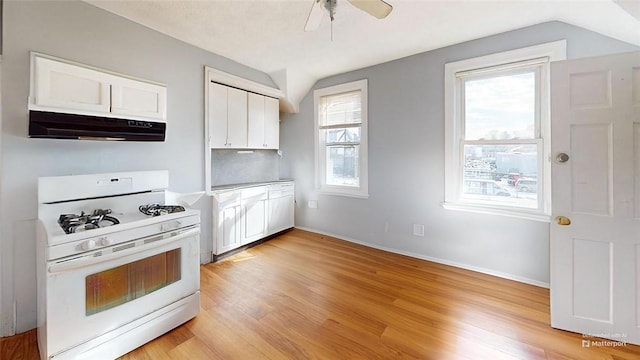 kitchen with white cabinetry, lofted ceiling, light wood-type flooring, and white gas range oven