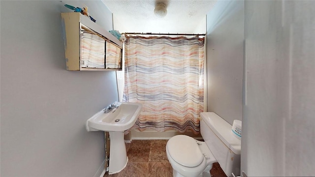 bathroom with toilet, tile patterned flooring, a textured ceiling, and shower / bath combo