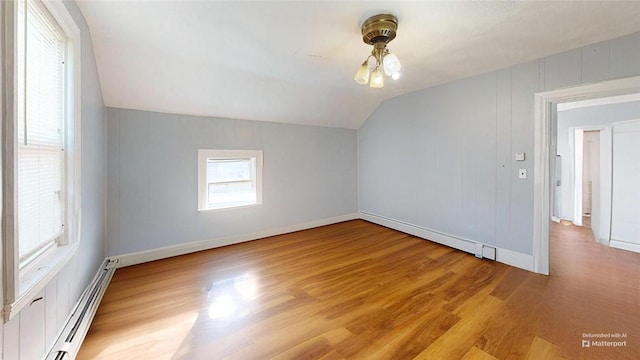 bonus room with lofted ceiling, light hardwood / wood-style flooring, and a baseboard radiator