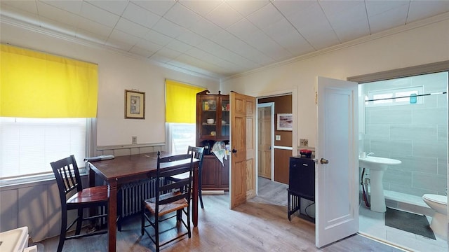 dining room with crown molding, hardwood / wood-style flooring, and a wealth of natural light